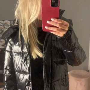 Svart glansig dunjacka från Calvin Klein - Säljer en snygg svart glansig dunjacka från Calvin Klein. Perfekt för vintern. Jackan är i mycket bra skick.