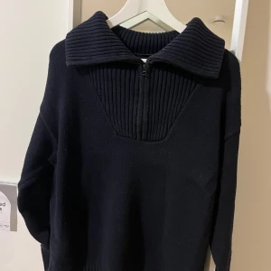 Marinblå stickad tröja från Zara - Säljer en snygg marinblå stickad tröja från Zara. Den har en dragkedja framtill och en stor krage som ger en cool look. Perfekt för höst och vinter. Tröjan är i mycket bra skick och redo för en ny ägare!