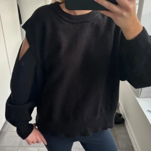 Svart stickad tröja med öppna axlar - Säljer denna så snygga och eftertraktade svarta stickad tröja med en cool design som har öppna axlar från Zara!! Så snygg😍😍