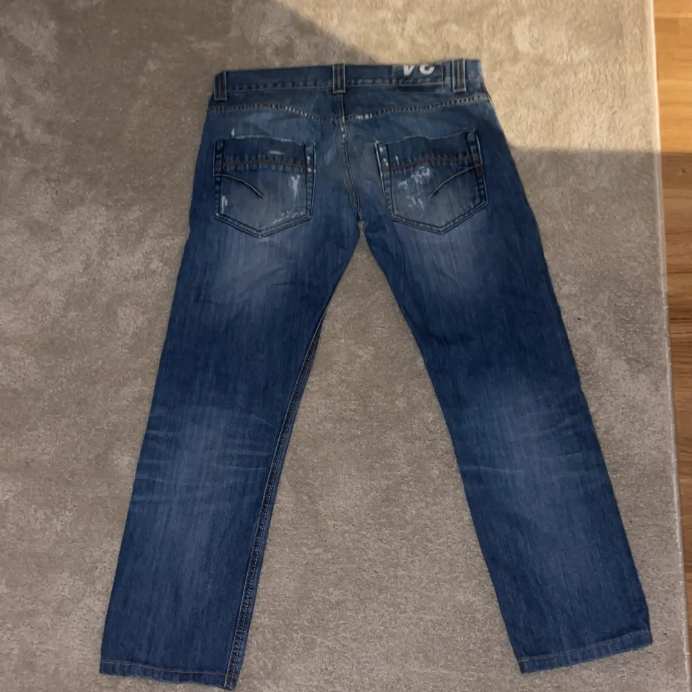 Säljer ett par snygga blå jeans från Dondup med coola slitningar. De har en klassisk femficksdesign och en bekväm passform. Perfekta för en avslappnad stil och funkar året runt. Passar både till vardags och fest!. Jeans & Byxor.