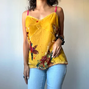 Gult blommigt linne - • Soft yellow velvet camisole top with red and green flower print and pink shoulder straps  • SIZE - L/ EU 40/42 / US 12/ UK 16 (Fits XS-L) • BRAND - Odd Molly • MATERIAL - 75% viscose, 25% polyamide   topp linne gul gult röd grön rosa blommig sammet