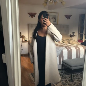 Beige kappa - Säljer denna beige kappa i mycket bra skick. Perfekt för höst och vår, med en klassisk design som passar till allt. Den har långa ärmar och en rak passform som funkar till allt. Den är från zara och knappt använd. Storlek M men skulle funka som S också. Pris kan diskuteras