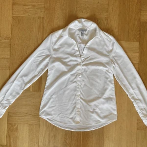 Vit V-ringad skjorta - Vit V-ringad skjorta i storlek xs. Skjortan är i gott begagnat skick och är enbart använd fåtal gånger. Klicka gärna på köp nu och meddela för eventuella frågor. :)