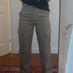 Beige cargobyxor - Säljer ett par beige cargobyxor med hög midja och fickor på sidorna. Från Stradivarius. Använda max ett par gånger, säljer då de är lite små på mig.