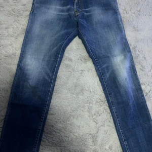 Blå jeans från Dsquared2 - Snygga blå jeans från Dsquared2 med en klassisk femficksdesign. De har en knappgylf och en läderpatch med logotypen på baksidan. Perfekta för en stilren look.