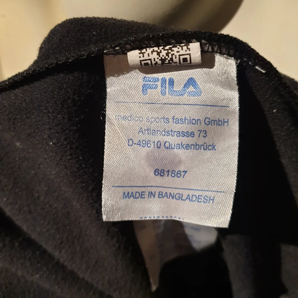 Snygg svart träningsjacka från Fila med dragkedja och logotyp på bröstet. Jackan har långa ärmar med Fila-tryck längs sidorna. Perfekt för en sportig look!. Neuletakit & Villapaidat.
