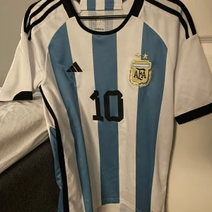 Argentina fotbollströja med nummer 10 - Säljer en en riktig snygg Argentina tröja för enbart 350kr, nypris ligger på 1100kr, baksidan är det nummer 10 med Messi på ryggen, knappt använd och skick är 10/10!!