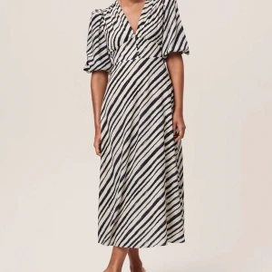 Slutsåld adoore klänning - Säljer nu denna helt oanvända Adoore klänningar med alla lappar kvar🤍. Den har varit helt slutsåld i storlek ett långt tag! Det är en midiklänning med knappar framtill och ”ränder”✨