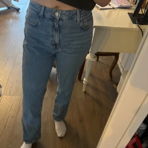 Blå jeans - Säljer ett par klassiska blå jeans med medel hög midja och rak passform. Perfekta för en avslappnad stil. Storlek 29/32.