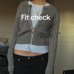 Grå ribbad kofta med dragkedja - Snygg grå ribbad kofta med dragkedja framtill. Perfekt för lager-på-lager och har en croppad passform som ger en modern look. Långärmad design som passar bra till både jeans och kjol.