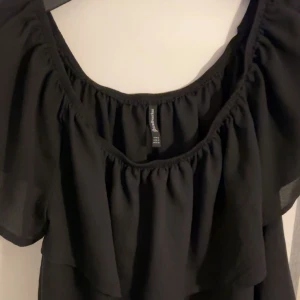 Blus - Säljer denna fina svarta blusen från stradivarius med korta ärmar och volangdetaljer. Kan styla till massa!  Blusen har en lös passform och är tillverkad i ett lätt material!🩷😇 i storlek S, använd 2 gånger, skicka vid bilder mm så löser vi det på bästa sätt annars är det bara att köpa ❣️❣️