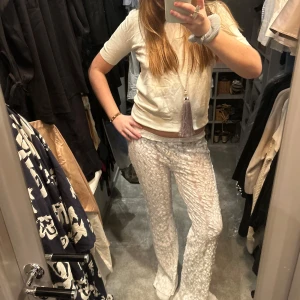 Vit kortärmad topp - Säljer en stilren vit kortärmad topp med rund hals. Toppen är enkel och passar perfekt till både vardag och fest. Den är gjord i ett mjukt material som ger en bekväm passform. Passar M/38!