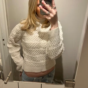 Vit stickad tröja - Säljer en mysig vit stickad tröja med ett snyggt mönster. Tröjan har långa ärmar och en croppad passform som ger en trendig look. Perfekt för kyligare dagar och att matcha med jeans eller kjol. Den är i strl M men skulle säga att den är mer som en S💕💕