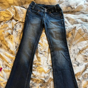 Mörkblå lågmidjade jeans med lite utsvängda ben - Snygga mörkblå jeans med väldigt låg midja och något utsvängda ben. De är skit snygga men tyvärr för små för mig:((
