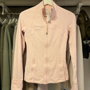 Träningsjacka  - Lululemon Define jacket i färgen Strawberry Milkshake, storlek 4. Superbra skick använd fåtal gånger 💖 lite skrynklig på bilderna men tvättas självklart innan jag skickar! 