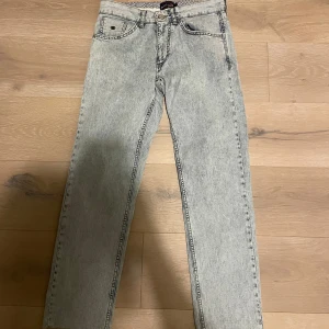 Ljusblå jeans från US Polo Assn - Snygga ljusblå jeans från US Polo Assn med en klassisk femficksdesign. De har en knappgylf och en läderpatch med logotyp baktill. 