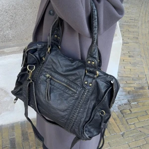 Svart väska från designbysi - Svart handväska med medföljande axelband. Går bra att bära både på axeln eller tvärsöver. Väskan är i nyskick och är aldrig använd.( EJ SKINN)