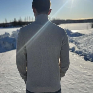 Beige långärmad piké tröja från bläck! - Säljer en stilren beige långärmad piké  tröja från bläck! Tröjan har en klassisk krage och knappar framtill. Perfekt för kyligare dagar med sin mjuka och bekväma passform.