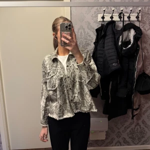Jeans jacka med orm-mönster  - Jätte fin jeans jacka med orm mönster och små nitar som detaljer. Längre bak än fram, allt är helt på den.