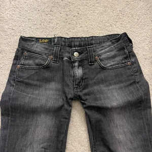  jeans från Lee - Gråa jeans från Lee. Jeansen är lågmidjade och bootcut som är tillsydd väldigt fint vid benen. Innerbenslängden är 78, midjemåttet är 38❤️ storlek W28, L31. Passar som en s❤️