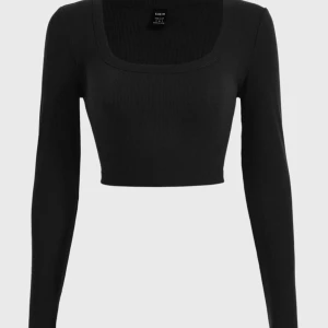 Svart ribbad croppad topp - Säljer en stilren svart ribbad croppad topp från Shein. Toppen har en fyrkantig halsringning och långa ärmar, perfekt för en trendig look.