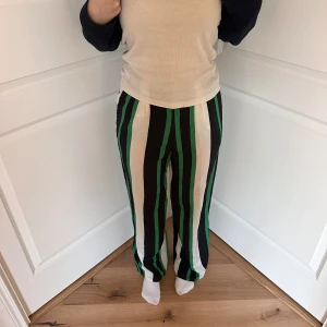 Randigakostym byxor från Topshop stl XS - Snygga randiga byxor från Topshop i grönt, svart och vitt. Passar perfekt till våren, eller kanske en studentskiva! Kan skicka samma dag och sänka pris vid snabb affär! Köpta i London och helt oanvända utan prislapp 