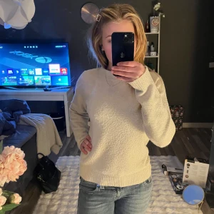 Beige stickad tröja - Säljer en mysig beige stickad tröja med rund hals och långa ärmar. Perfekt för kyligare dagar och enkel att matcha med jeans eller kjol. Tröjan har en klassisk design med ribbstickade muddar vid ärmslut och nederkant.