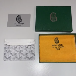 Korthållare  - PRIS KAN DISKUTERAS VID SNABB AFFÄR!!                                                                             Säljer en elegant vit och grå plånbok med ett ikoniskt mönster. Plånboken har en stilren design och är perfekt för att hålla dina kort och kontanter organiserade. Kommer med originalförpackning och dustbag.                              Tveka inte på att fråga 🙋 