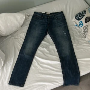 Blå jeans från Jack & Jones - Snygga blå jeans från Jack & Jones med slim fit passform. De har en klassisk femficksdesign och är tillverkade av kvalitetsbomull. Perfekta för en stilren look. 9/10 skick andvända nån gång men i bra skick