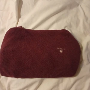 Vinröd tröja från GANT - Säljer en stilren vinröd tröja från GANT i premium bomull. Tröjan har en diskret logga på bröstet och ribbstickade kanter vid halsen. Perfekt för en avslappnad men ändå snygg look.