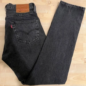 Mörkgrå jeans från Levi's - Snygga svarta Levi's 501 jeans i klassisk design. De har en rak passform och är tillverkade i slitstarkt denim. W29 L32