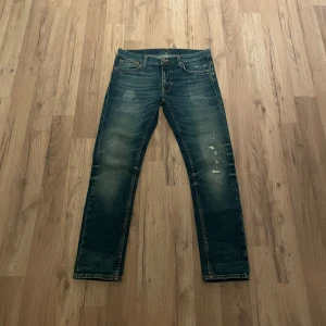 Nudie Jeans - Snygga mörkblå jeans med coola slitningar och klassisk femficksdesign. De har en rak passform och är perfekta för en avslappnad stil. Märkesdetaljer på bakfickan ger en extra touch. Nypris: 1800. Mitt pris: 699. Dessutom kan pris diskuteras.