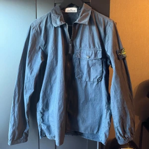 Stone Island Overshirt - Säljer en snygg blå overshirt från Stone Island med dragkedja och en bröstficka med knapp. Storlek S. Nypris ca 4600. Mitt pris 1300