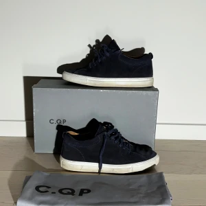 Mörkblåa sneakers från C.QP - Snygga mörkblåa sneakers från C.QP i mocka med snörning. Perfekta för en stilren look. Skorna kommer med originalkartong, dustbag och kvitto