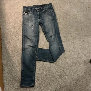 Tiger of Sweden jeans - Ett par jävligt snygga jeans från tiger of Sweden. ✨SLIMFIT✨Okej skick pga att de är tunna eftersom de använts länge, därför KAN hålen växa. 4 hål. 2 på vänster ben, 1 lagat på höger och ett i fickan. Skriv vid minsta fråga🙌