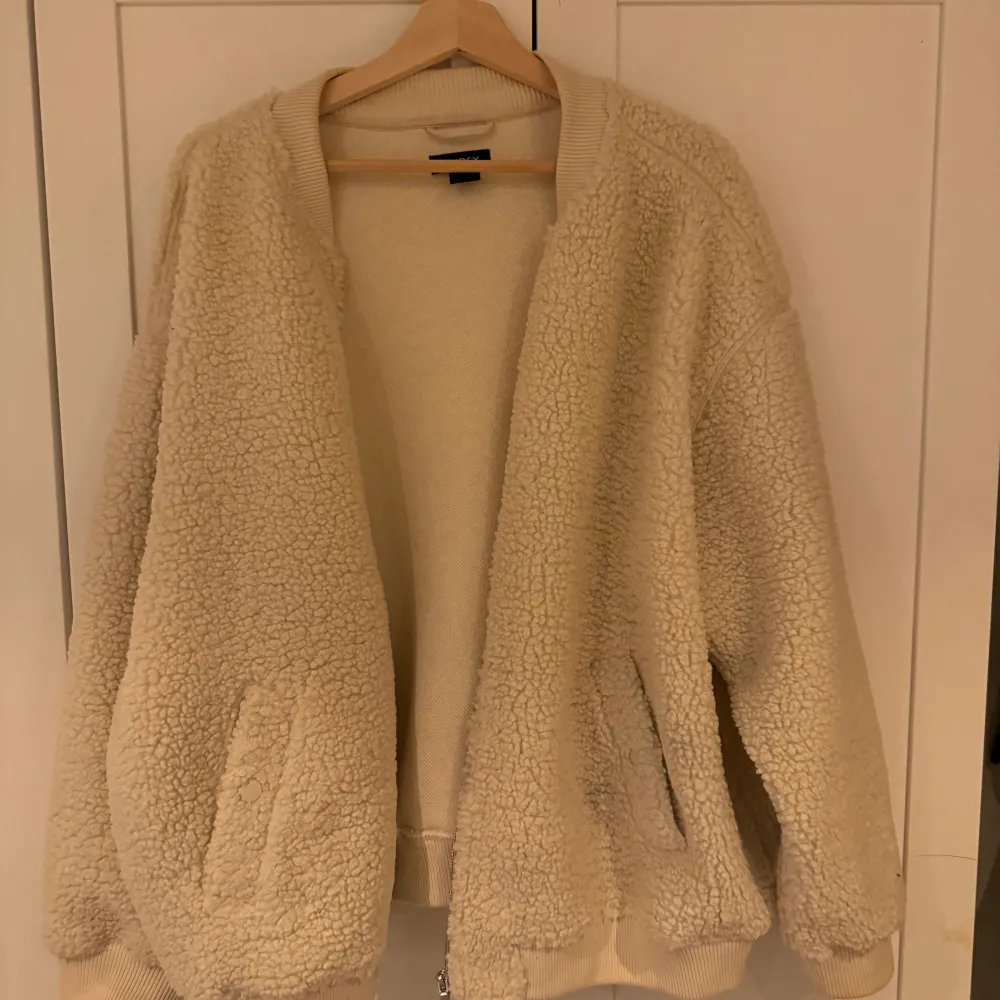 Mysig beige viral  teddyjacka från Lindex i storlek XL men passar bra på mig som är en M. Perfekt för kyliga höst- och vinterdagar. Jackan har en avslappnad passform med långa ärmar och dragkedja framtill. Den är supermjuk och håller dig varm och stilren hela säsongen.. Jackor.