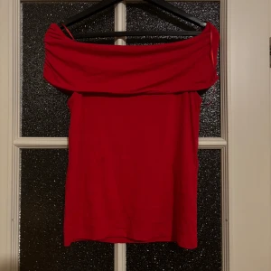 Röd offshoulder topp - Snygg röd offshoulder topp perfekt för festliga tillfällen. Den har en elegant design som ger en chic look!