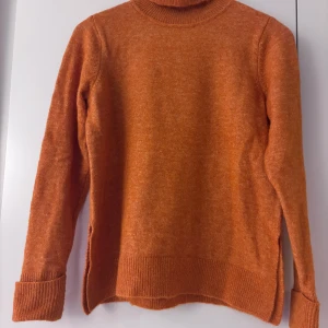 Orange stickad polotröja från Selected Femme - Säljer en superfin orange stickad polotröja från Selected Femme i storlek XS. Perfekt för höst och vinter med sin varma och mysiga känsla. Tröjan har långa ärmar och ribbade detaljer vid ärmslut och nederkant. Passar perfekt för en stilren och bekväm look! 🍂🧡