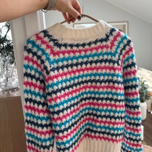 Färgglad stickad tröja från Zara - Säljer en superfin stickad tröja från Zara i härliga färger! Den har ett mönster i vitt, rosa och blått. Perfekt för höst och vinter när du vill vara både varm och stilren. Tröjan är i mycket bra skick och redo för nya äventyr! Står M i men passar S