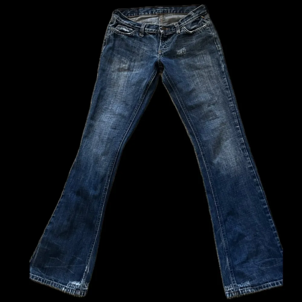 Säljer ett par snygga blå bootcut jeans i bra skick. De är lågmidjade och har en klassisk femficksdesign. Perfekta för en avslappnad stil och passar till både vardag och fest. Sköna och stilrena! Jag är 169 och passar bra i längden. Midjemått tvärsöver - 38cm och innerbenslängd - 83cm. Jeans & Byxor.