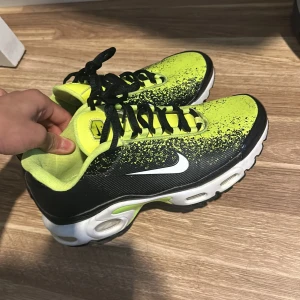 Nike sneakers i svart och neon - Säljer ett par coola Nike sneakers i svart och neon. De har en unik färgkombination med svart bas och neonfärgade detaljer. Skorna har snörning och en bekväm sula, perfekt för träning eller vardagsbruk. De är i bra skick och redo för nya äventyr!