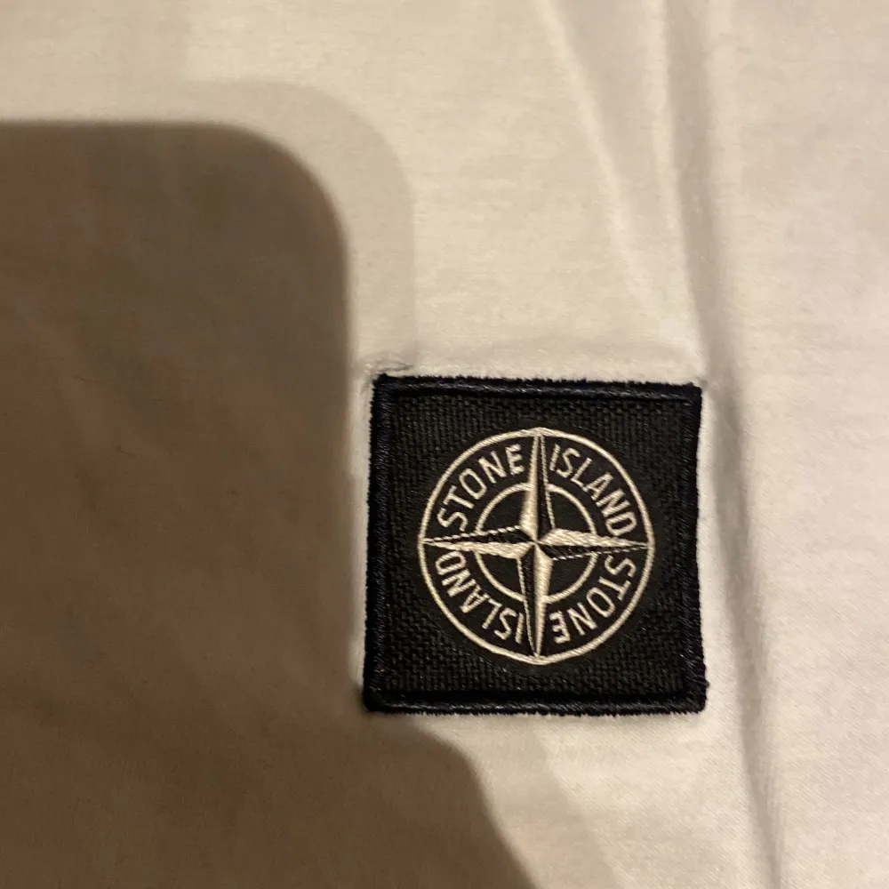 Säljer en snygg vit t-shirt från Stone Island. Den har ett litet håll vid märket men annars top skick. Säljer pga för liten.. T-shirts.