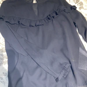 Blå blus från ONLY - Säljer en elegant blå blus från ONLY i storlek 34. Blusen har långa ärmar och en fin volangdetalj. Perfekt för både vardag och festliga tillfällen. Skön och stilren design som passar till det mesta. 