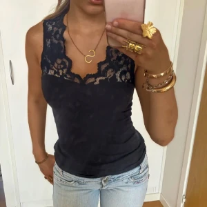 Svart ärmlös topp med spetsdetaljer - Skitsnyggt spetslimne . Perfekt för både vardag och fest👌🏻💗