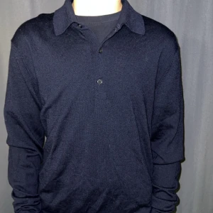 Svart  uniqlo tröja - Säljer en stilren svart tröja från Uniqlo i storlek XS. Tröjan har en klassisk krage och knappar framtill. Perfekt för både vardag och lite finare tillfällen. Den är i bra skick och passar perfekt till höst- och vintergarderoben.✌🏼💶