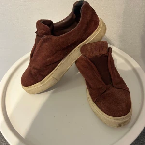 Eytys sneakers  - Säljer ett par bruna sneakers i mocka med en chunky vit sula. De är i bra skick och perfekta för en avslappnad stil. Passar bra till både jeans och chinos. Skorna har en enkel design utan snörning, vilket gör dem lätta att ta på och av.