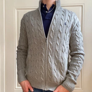 Ralph Lauren kofta - Säljer en snygg grå stickad kofta från Ralph Lauren i storlek S/M från den nya kollektionen, med QR kod. Perfekt för höst och vinter, och den är i grymt skick utan några defekter:) Passar både till vardags och lite finare tillfällen. 🥂Nypris ligger på 2799 och nu för 990kr. 