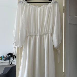 Vit klänning från Glamorous - Säljer en superfin vit klänning från Glamorous i storlek XS. Den har långa ärmar och en elastisk midja som ger en bekväm passform