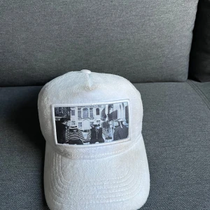 Vit keps med fototryck.  - Snygg vit keps med ett coolt svartvitt fototryck på framsidan. Perfekt för att ge din outfit en unik touch. Kepsen har en klassisk design med böjd skärm och justerbar passform. Passar bra till både vardag och fest!