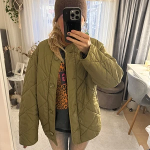 Olivgrön quiltad jacka - Säljer en olivgrön quiltad jacka i oversized passform. Den har långa ärmar och knappar framtill. Perfekt för höst och vår❣️❣️
